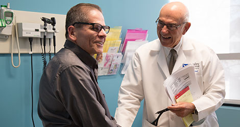 Volunteer Doctor meeting with a male patient in a BVMI exam room.