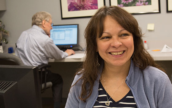 Front desk associate, Rebeca, at the BVMI reception desk, ready to greet patients.